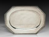 une assiette en argent ornée d'un motif décoratif sur le bord