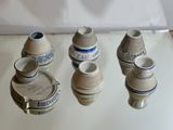 cinq petits vases posés sur une table, sur fond blanc