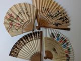 quatre éventails en bois ornés de motifs floraux sur fond blanc