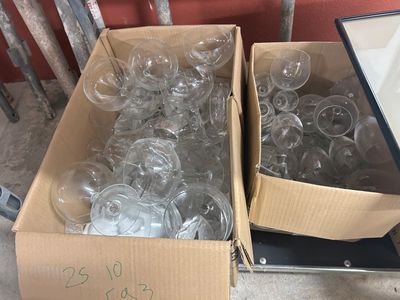 deux cartons de verres à vin vides posés par terre