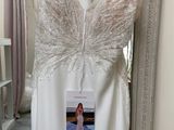 a wedding dress hanging on a rack in a room