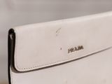 a white purse sitting on top of a wooden table