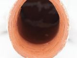 close up of a pipe on a white surface with a white background