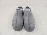 grey sued slip on shoes with black trims on a white surface