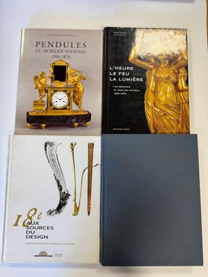 plusieurs livres posés sur une table, à côté d'une horloge et d'un stylo