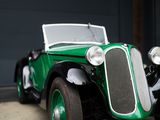 a green car parked in front of a garage door