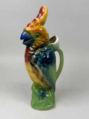 a colorful bird that is sitting on top of a pitcher