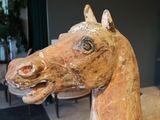 a wooden horse head on display in a room
