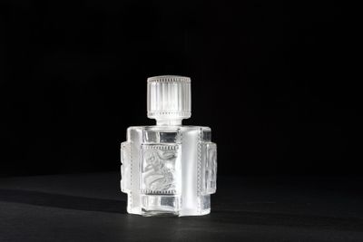 a close up of a bottle of perfume on a black surface