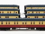 four toy trains are lined up on a white surface