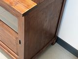 un meuble en bois surmonté d'une porte en verre