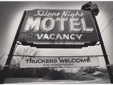 photographie en noir et blanc d'une enseigne de motel avec un camion en arrière-plan
