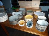many plates and bowls sitting on a wooden table
