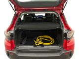 the back of a red car with a hose in the trunk