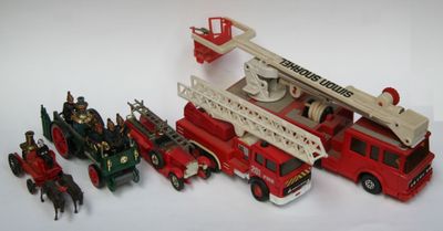 un camion de pompiers miniature et d'autres véhicules miniatures posés sur une surface blanche