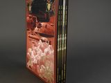 three books are stacked on top of each other on a gray surface