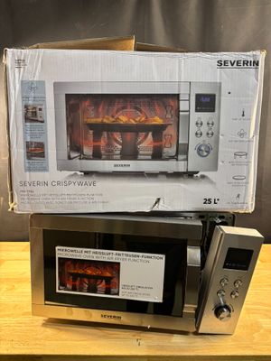 two microwaves sitting on top of each other on a table