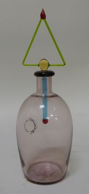 a pink glass vase with a green triangle on top of it