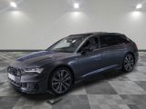 une Audi break grise garée dans un garage au sol carrelé