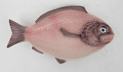 a pink fish that is sitting on a white surface