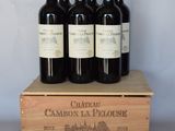 quatre bouteilles de vin se trouvent dans une caisse en bois posée sur une table