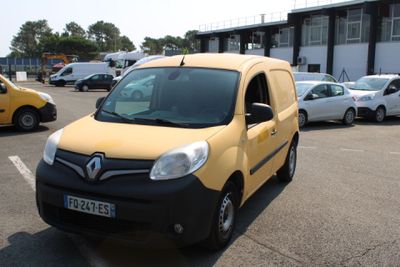 une camionnette jaune garée sur un parking à côté d'autres voitures