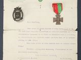 an old letter with a medal and a medal pin on a piece of paper