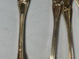 four spoons are lined up in a row on a white surface