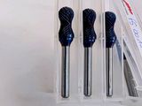 three blue drill bits are in a clear holder on a white surface