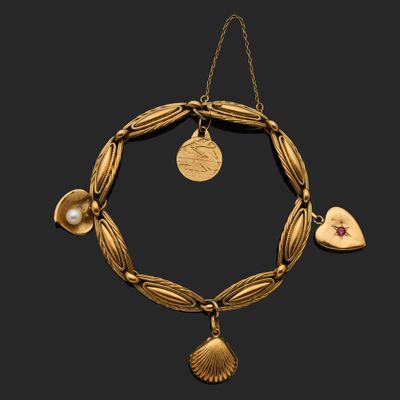 un bracelet en or orné d'un pendentif en forme de cœur et de coquillage
