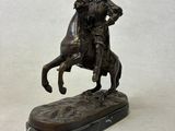 statue of a man riding a horse with a dog on it