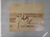 an old photo of a man standing next to a horse