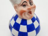 une petite figurine en céramique bleue et blanche représentant un clown