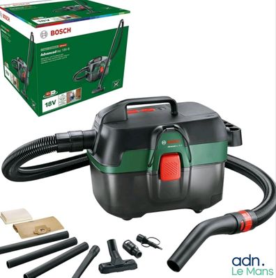 a black and green vacuum cleaner with tools and a box