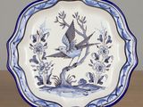 a blue and white plate with two birds on it