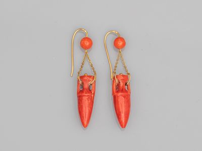une paire de boucles d'oreilles en corail rouge avec des chaînes en or
