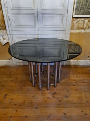 a glass table with a metal base in a room