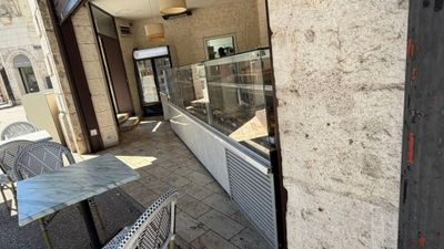 tables and chairs on a sidewalk outside of a restaurant