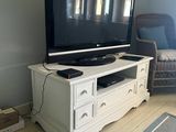 a flat screen tv sitting on top of a white entertainment center
