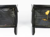 pair of black leather chairs with gold paint on them