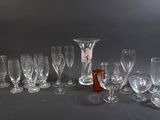 a lot of wine glasses and a bottle on the table