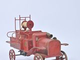 a red toy fire truck with a clock on the back of it