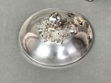 a silver plate with a flower on it on a table