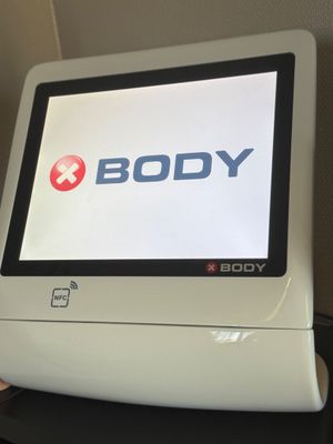 un écran d'ordinateur posé sur un bureau, avec le logo « Body » affiché à l'écran