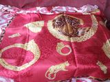 un sac rouge orné d'un tigre, posé sur un lit