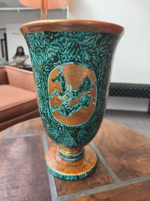 un vase vert posé sur une table en bois