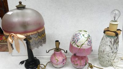 a table with a lamp, a lamp shade, a vase, and other items on it