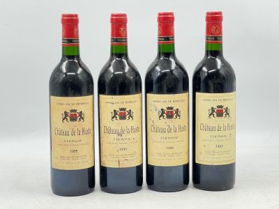 trois bouteilles de vin rouge sont alignées sur une surface blanche