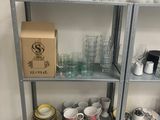 a shelf with a bunch of cups and plates on it