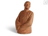 statue of an old man sitting on a chair with his arms crossed